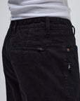 Black denim pants by FORMER AG, showing slim fit style with classic five-pocket design and belt loops.