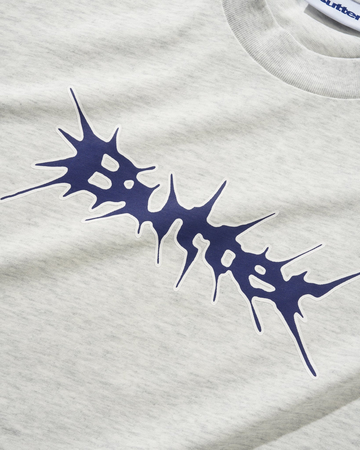 Butter Nail Logo T-shirt in ash gray with a nail logo graphic on the front